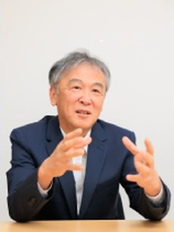 身ぶりを交えて話す、スーツ姿の男性