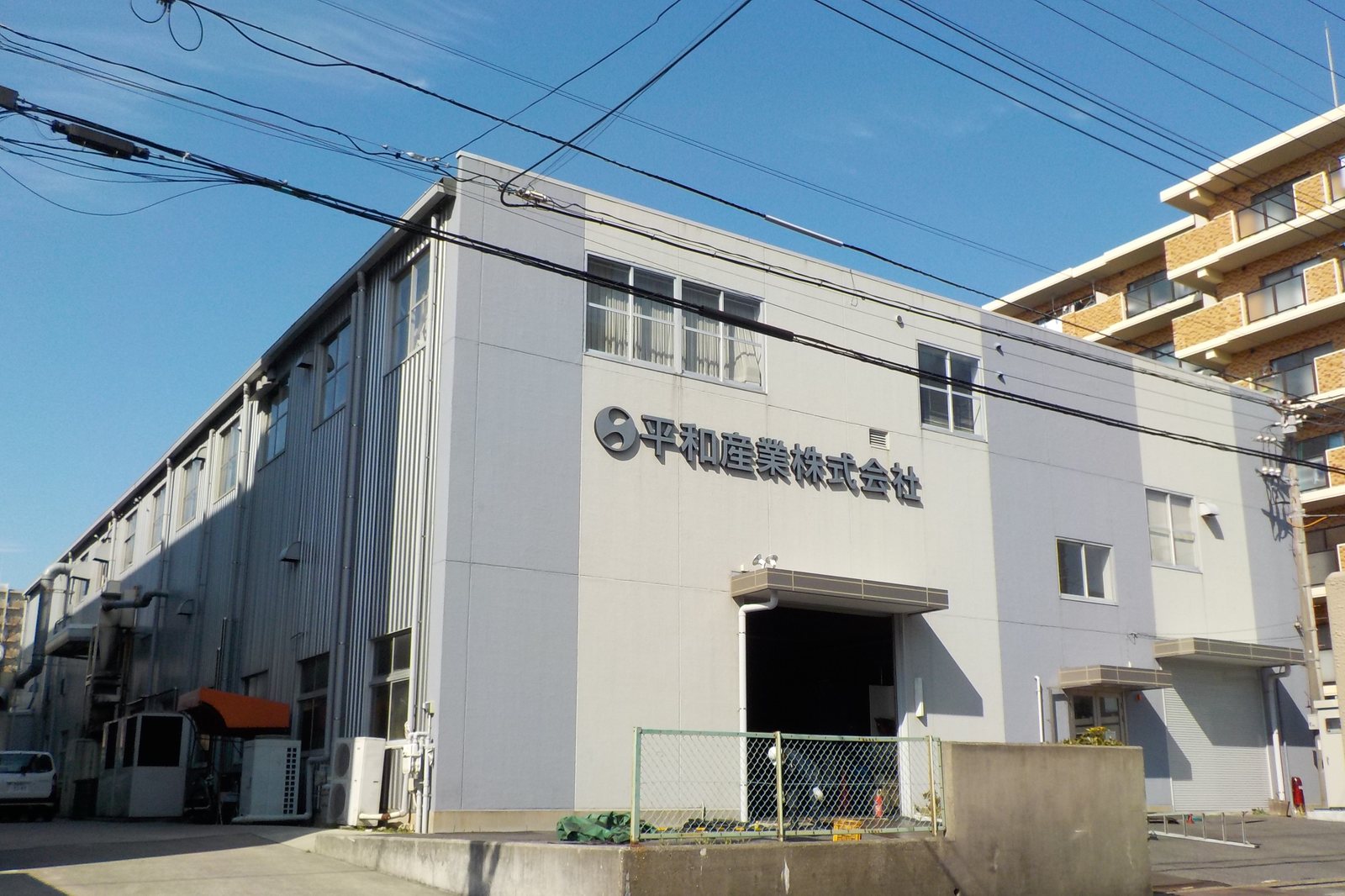 社名が入った、白い外壁の工場